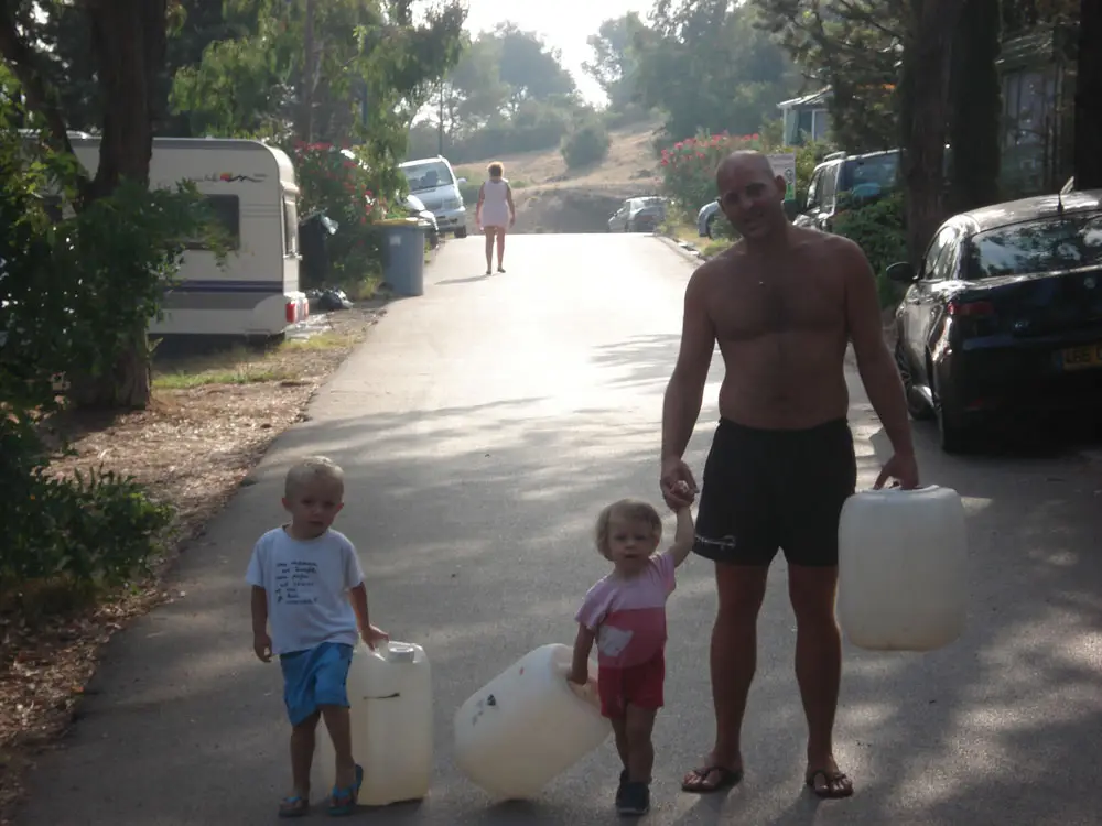 Papa et ses deux enfants en route pour remplir les bidons d'eau au camping Esterel Caravaning