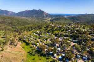 Vue aérienne du domaine d'Esterel Caravaning à Agay, ses emplacements sous les pins, le massif de l'Estérel et la mer à l'horizon