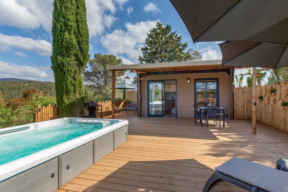 Terrasse du VIP Duo d'Esterel Caravaning avec son spa de nage privé, sa pergola et la vue sur le massif de l'Estérel