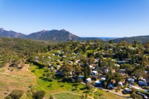 Vue aérienne d'Esterel Caravaning à Agay, ses emplacements dans la verdure et le massif de l'Estérel au loin