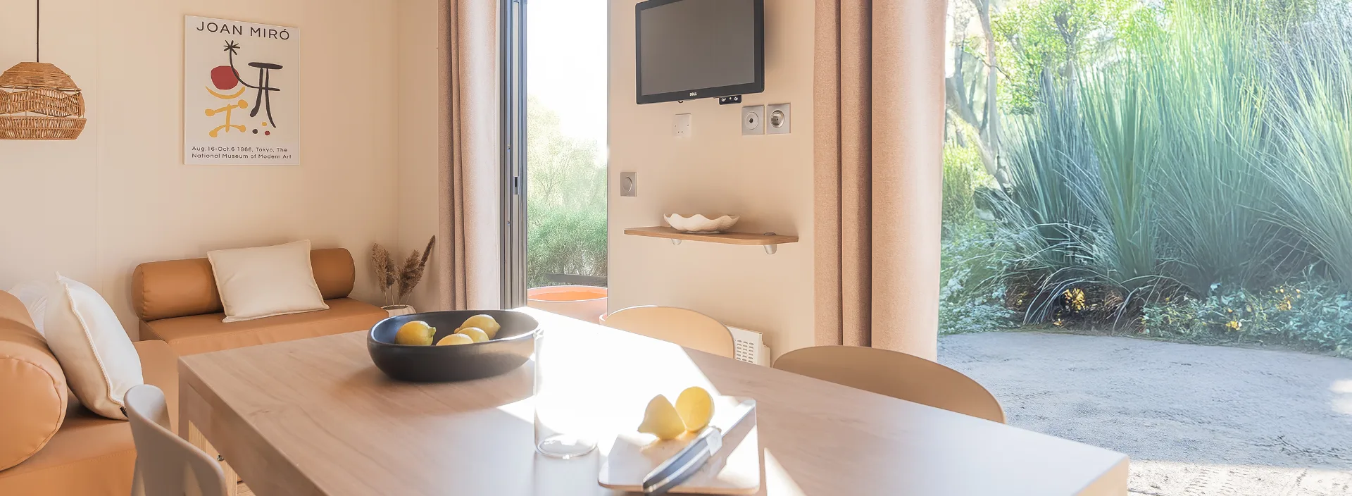 Pièce de vie du mobil-home Suite avec banquette, table et baie vitrée
