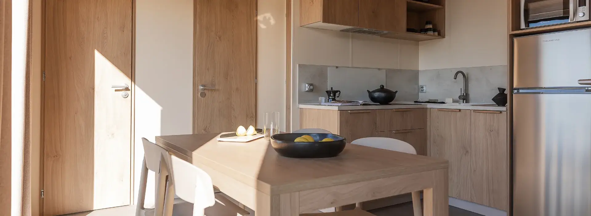Cuisine équipée du mobil-home Suite avec réfrigérateur et table à manger