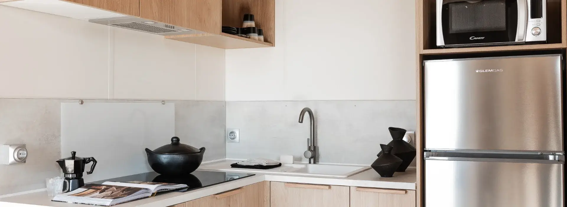Coin cuisine du mobil-home Suite : plaques de cuisson, évier, micro-ondes et réfrigérateur