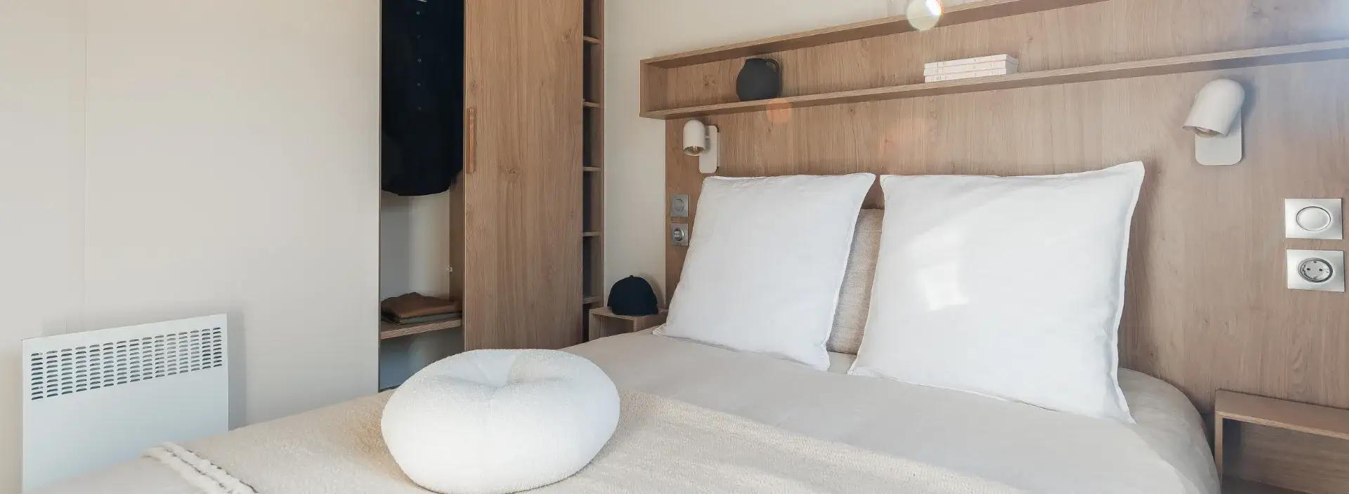Chambre parentale du mobil-home Suite avec lit double et tête de lit en bois