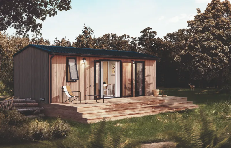Mobil-home Suite avec bardage bois et grande terrasse en bois au milieu de la végétation