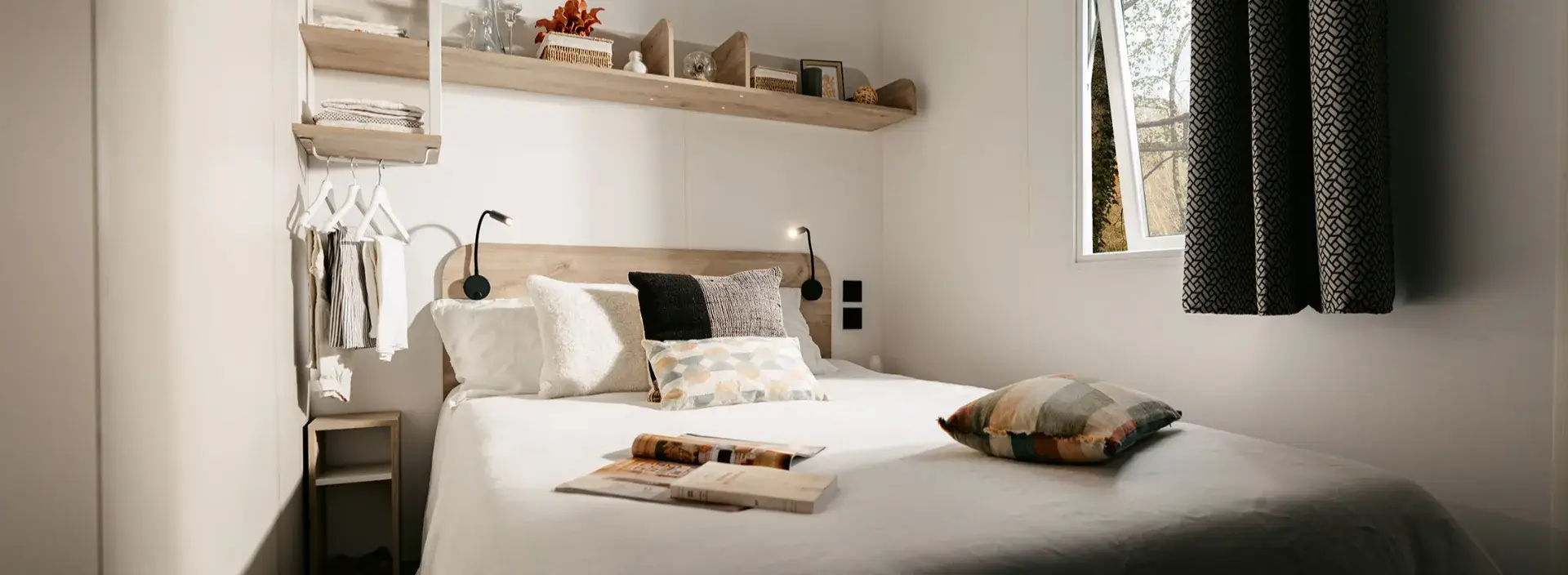 Chambre parentale du mobil-home Villa avec lit double et étagères